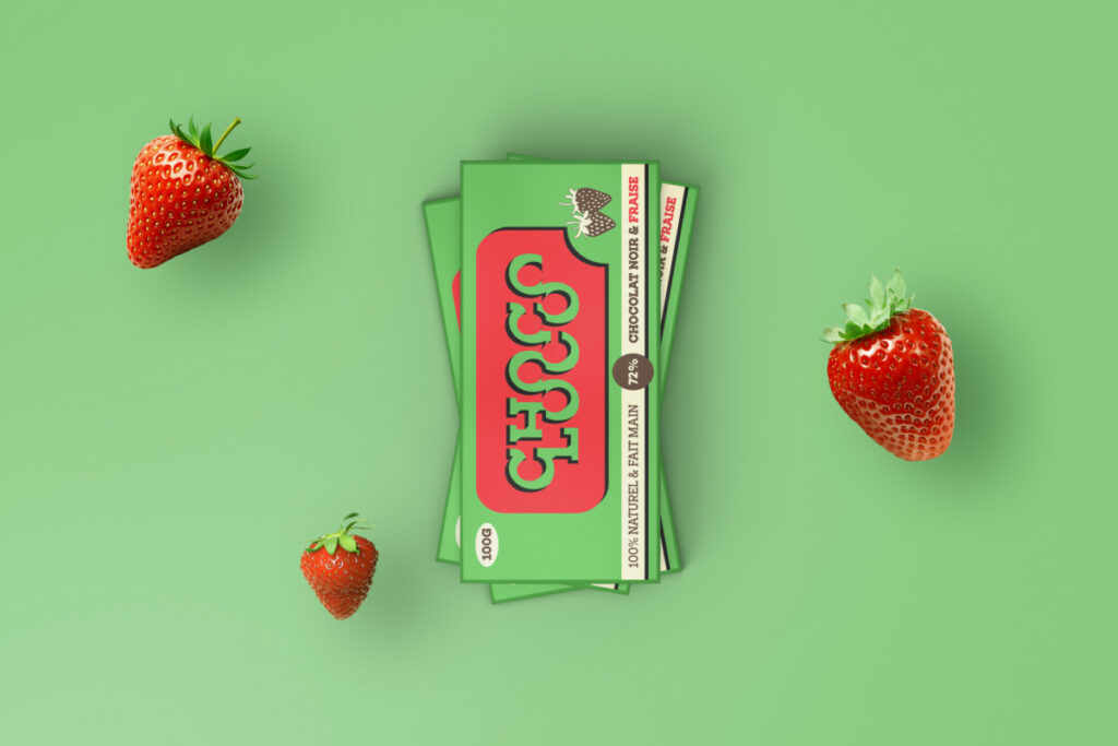 Des maquettes de tablettes de chocolat sur un fond vert, accompagnées de fraises fraîches autour.